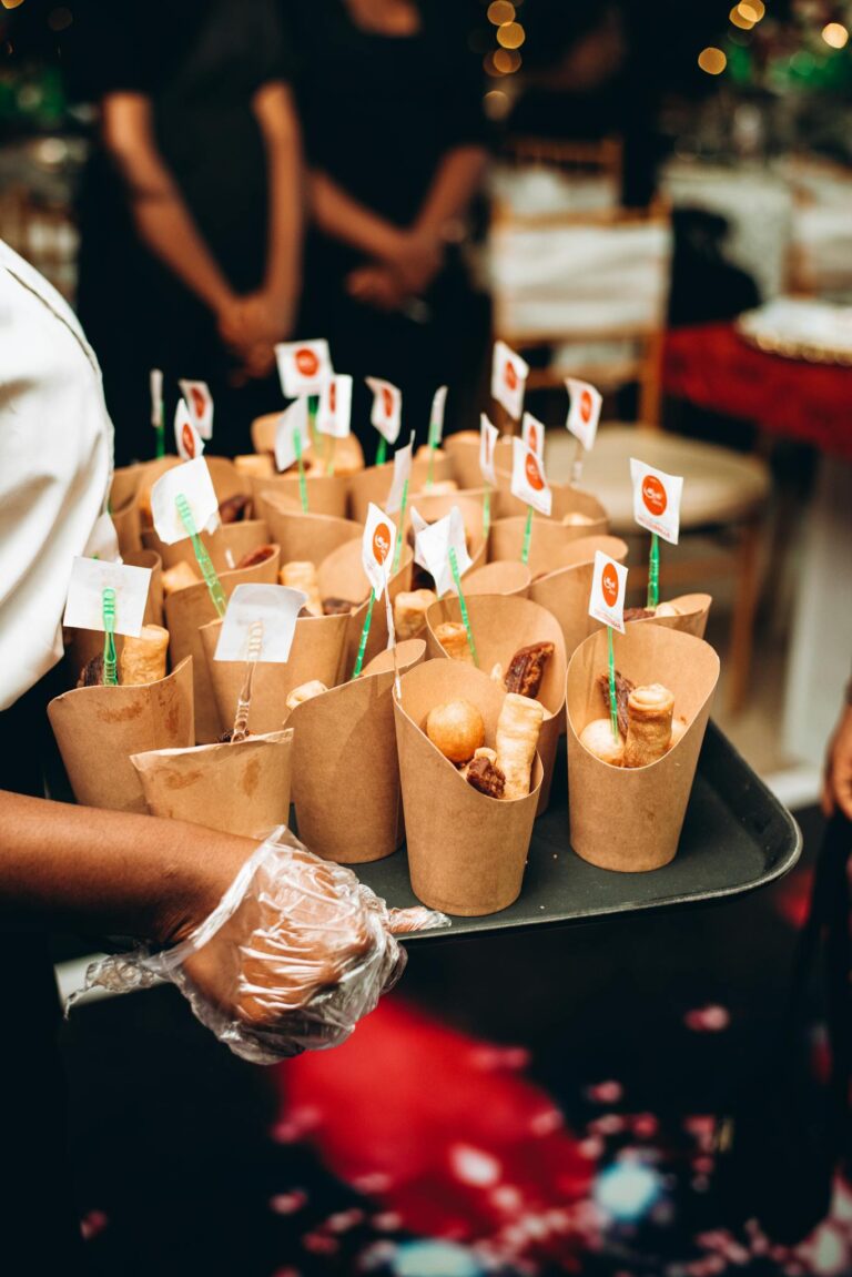 Elegant catering tray filled with assorted food cones at a stylish indoor event.